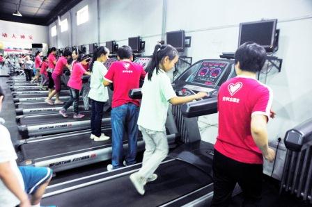 孩子们和志愿者在健身中心参观体验